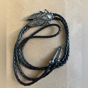 Western cicada bolo tie, featuring a silver tone metal insect pendant